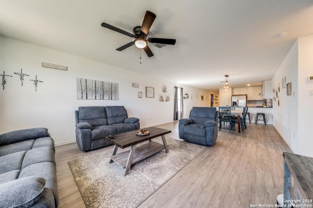 living room with light hardwood / wood-style flooring and ceiling fan