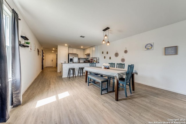 dining space with light hardwood / wood-style floors