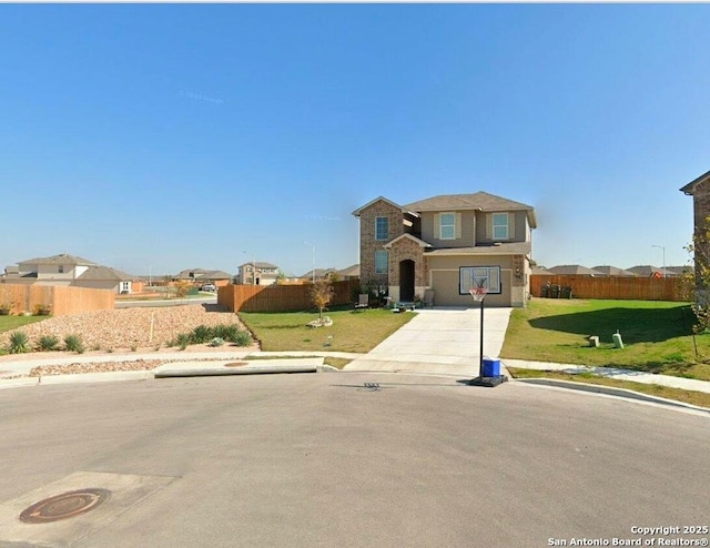 traditional-style house with concrete driveway, a front yard, and fence