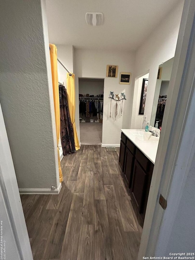 bathroom featuring hardwood / wood-style flooring, vanity, and walk in shower