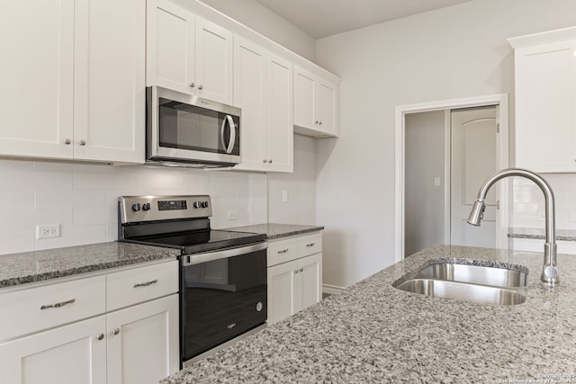 kitchen featuring backsplash, appliances with stainless steel finishes, sink, and white cabinets