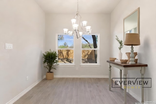 doorway to outside with an inviting chandelier and light hardwood / wood-style floors