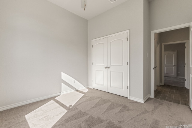 unfurnished bedroom with light colored carpet and a closet