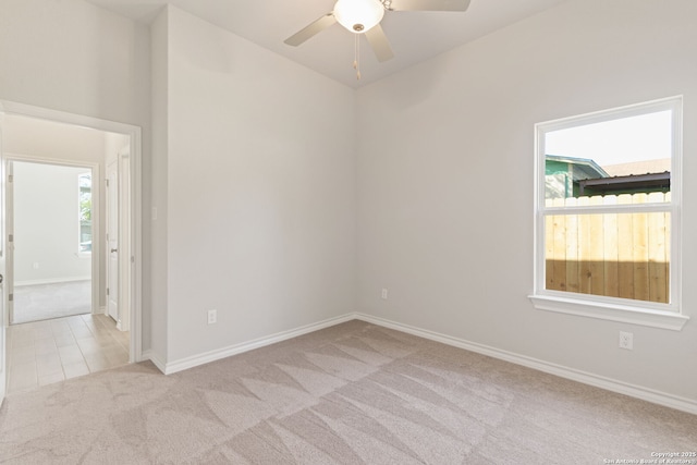 spare room featuring light carpet and ceiling fan