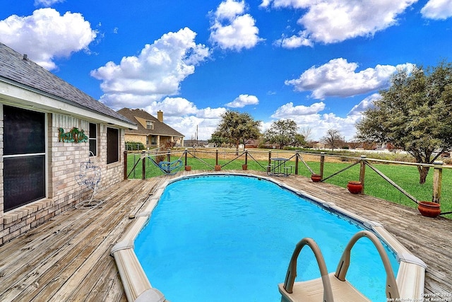 view of pool featuring a deck and a lawn