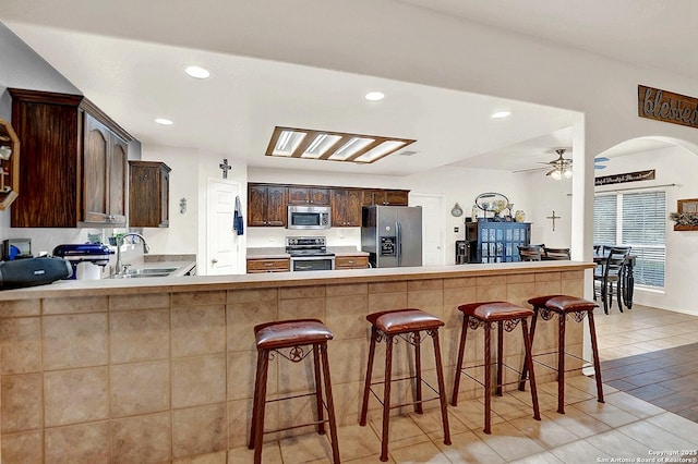 kitchen featuring stainless steel appliances, sink, a breakfast bar area, and kitchen peninsula