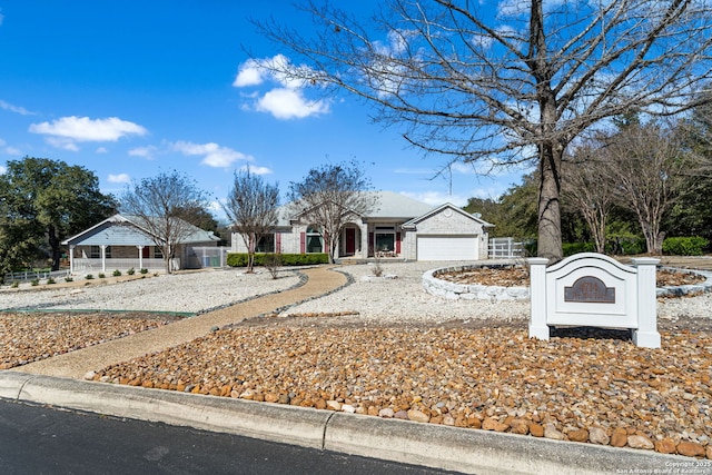 ranch-style home featuring a garage, fence, and driveway