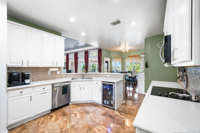 kitchen featuring wine cooler, stainless steel appliances, a sink, and light countertops