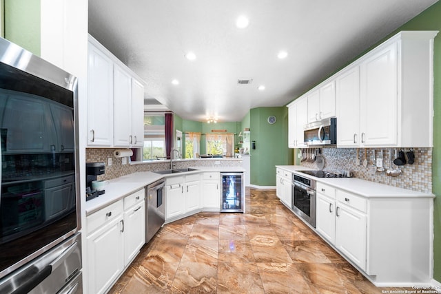 kitchen featuring light countertops, a sink, white cabinets, and stainless steel appliances