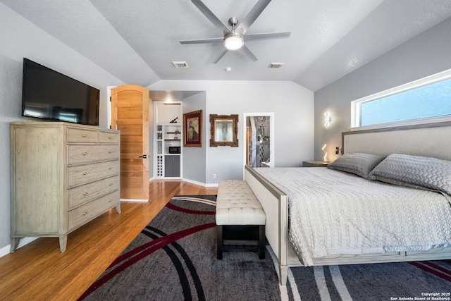 bedroom with lofted ceiling, light wood-style floors, ceiling fan, and visible vents