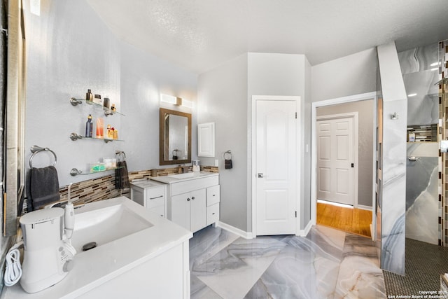 full bathroom with a sink, marble finish floor, two vanities, and baseboards