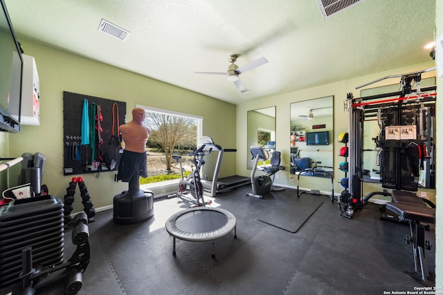 workout room with a textured ceiling, ceiling fan, visible vents, and baseboards