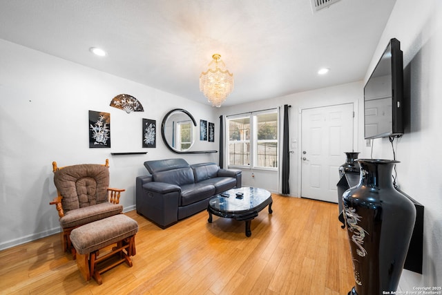 living area with a notable chandelier, baseboards, wood finished floors, and recessed lighting