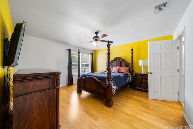 bedroom with light wood-type flooring, baseboards, visible vents, and a ceiling fan