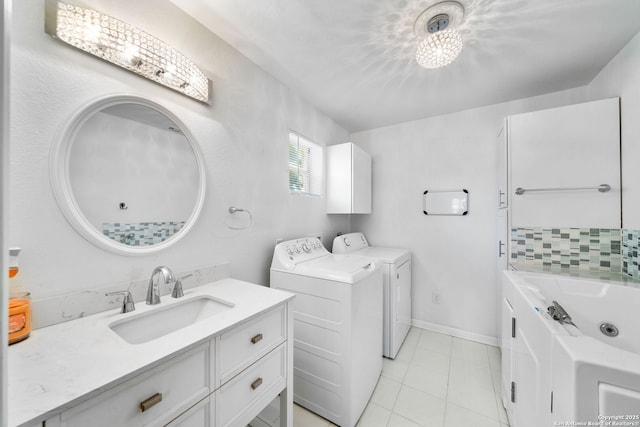 washroom featuring laundry area, a sink, baseboards, and light tile patterned floors