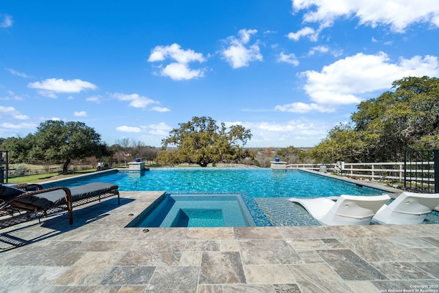 pool featuring a patio area, fence, and an in ground hot tub