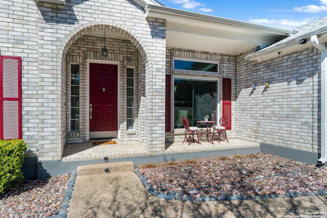 view of exterior entry featuring brick siding