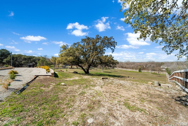 view of yard with a rural view and fence