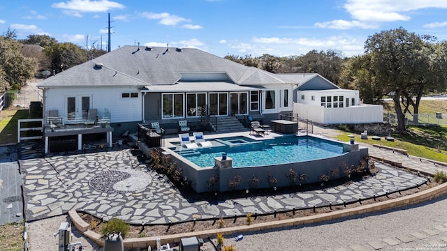 back of house with french doors, roof with shingles, a sunroom, a patio area, and an outdoor pool