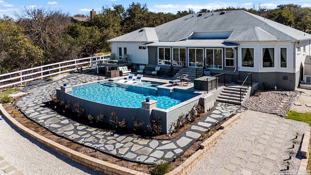 back of property featuring a patio, a shingled roof, fence, a sunroom, and a fenced in pool