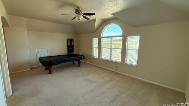 game room featuring lofted ceiling, pool table, light carpet, a textured ceiling, and ceiling fan