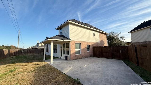 rear view of house featuring a yard and a patio area