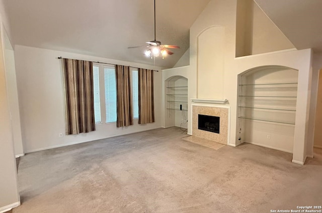 unfurnished living room with high vaulted ceiling, light carpet, built in features, ceiling fan, and a fireplace