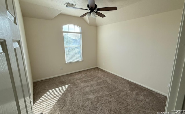 empty room featuring ceiling fan, lofted ceiling, and carpet flooring