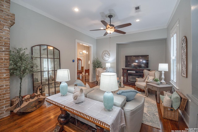 living room with hardwood / wood-style flooring, ornamental molding, and ceiling fan