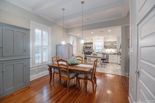 dining area with beamed ceiling and hardwood / wood-style floors