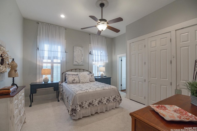 bedroom with multiple windows, light colored carpet, and a closet