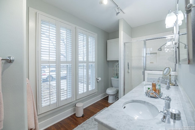 bathroom featuring plenty of natural light, toilet, wood-type flooring, and vanity