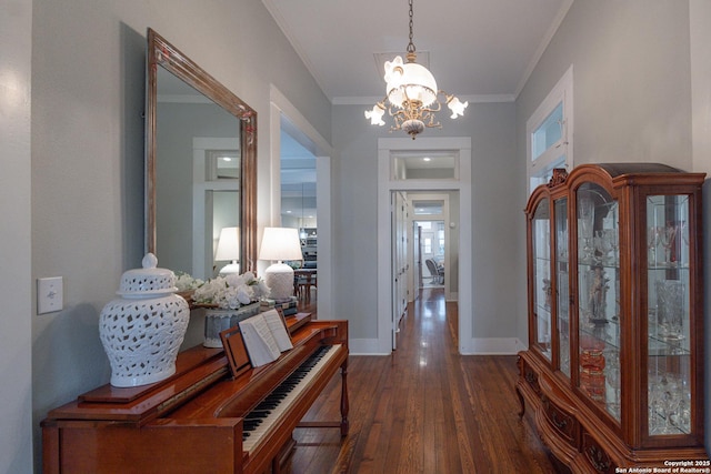 entryway with crown molding, dark hardwood / wood-style floors, and a chandelier