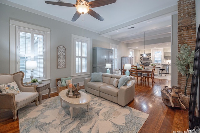 living room featuring ceiling fan, dark hardwood / wood-style flooring, and beam ceiling