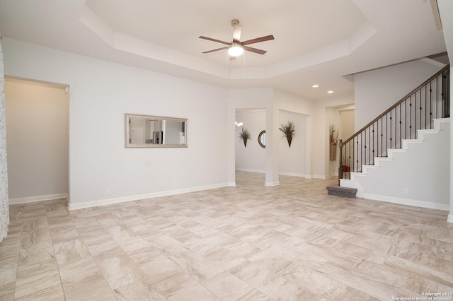 unfurnished room with a raised ceiling and ceiling fan