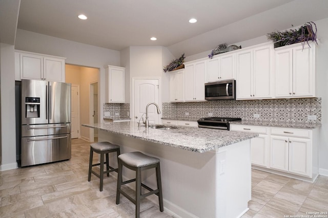 kitchen featuring white cabinetry, stainless steel appliances, sink, and a kitchen island with sink