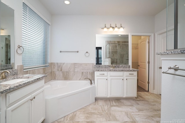 bathroom with vanity and shower with separate bathtub