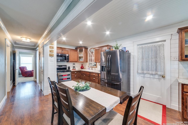 dining space featuring crown molding, sink, and dark wood-type flooring