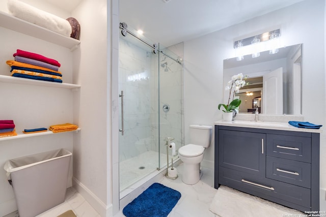 bathroom with vanity, toilet, and a shower with door