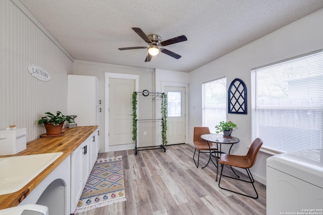 living area with sink, light hardwood / wood-style flooring, a textured ceiling, and ceiling fan