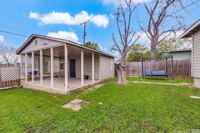 rear view of house featuring a patio area and a lawn