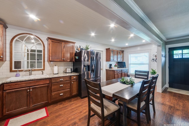 kitchen featuring sink, dark wood-type flooring, light stone counters, and stainless steel fridge with ice dispenser