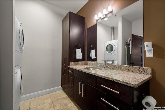 bathroom featuring stacked washer / drying machine, tile patterned flooring, and vanity