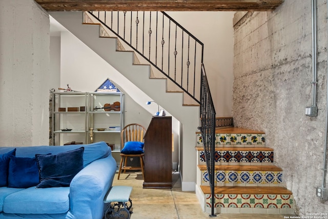 stairway with concrete flooring and a towering ceiling