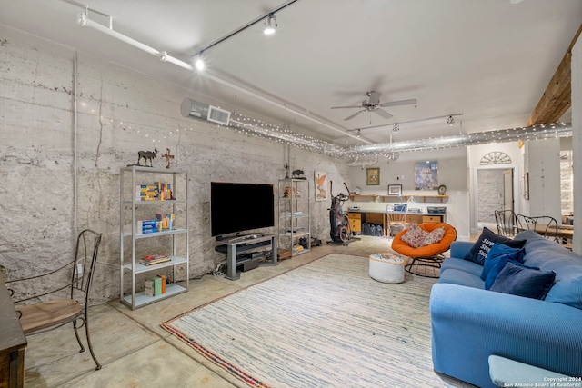 living room with ceiling fan, track lighting, and concrete flooring