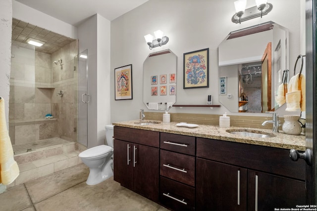 bathroom with vanity, toilet, a shower with shower door, and tile patterned flooring