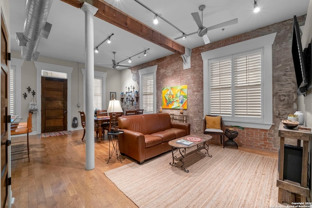 living room featuring light hardwood / wood-style flooring, ceiling fan, and brick wall