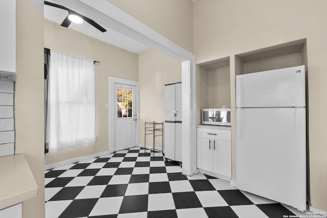 kitchen featuring white cabinets and white fridge