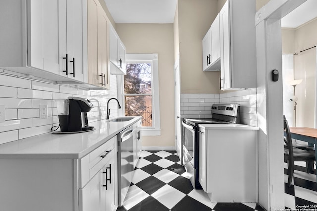 kitchen with white cabinetry, appliances with stainless steel finishes, sink, and tasteful backsplash