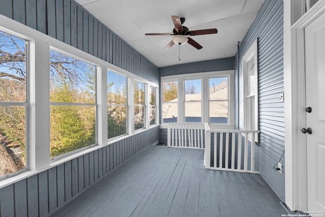 unfurnished sunroom with ceiling fan